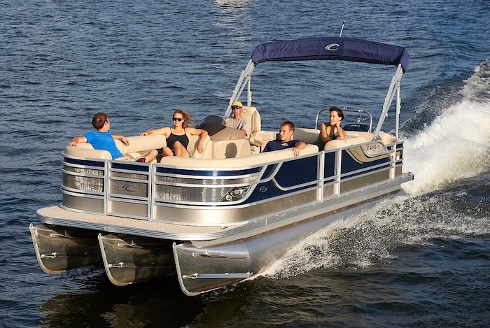 A group of people riding on a pontoon boat on a sunny summer day